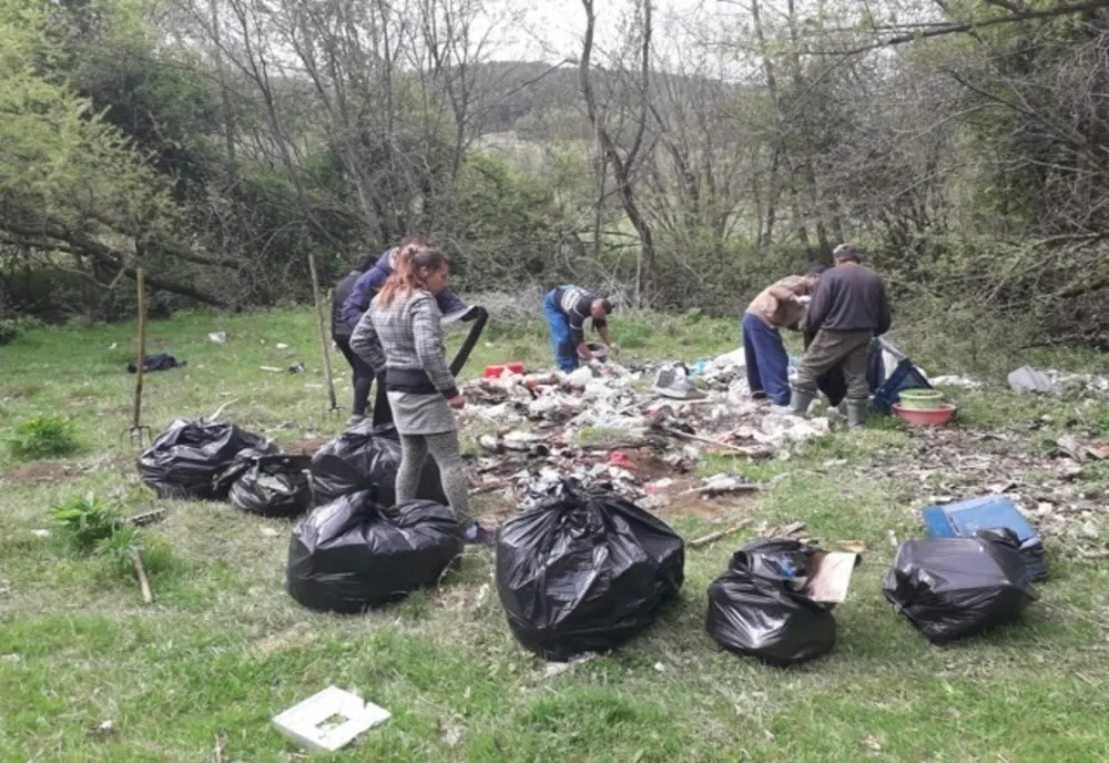 FOTO. Primăria Ozun a pus asistații social la treabă. Saci întregi de gunoaie adunați din spațiile verzi